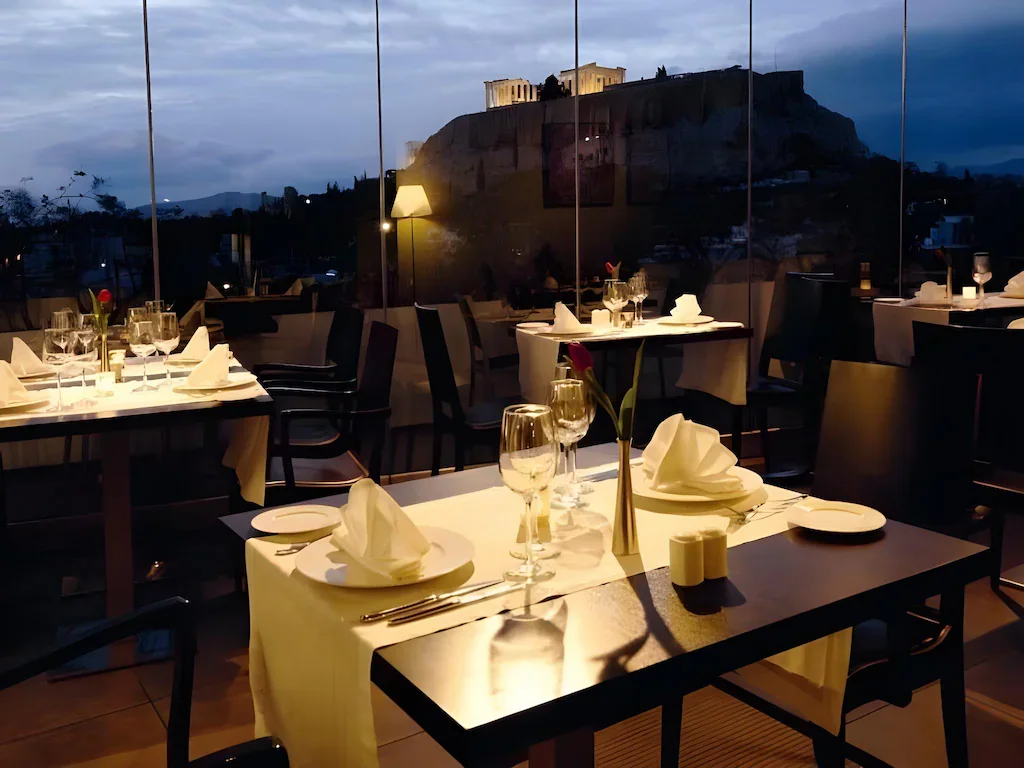 Večerní střešní restaurace hotelu The Athens Gate s výhledem na Akropoli