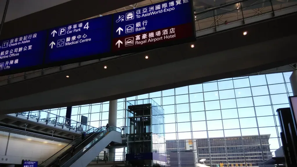Panneau vers le Regal Airport Hotel dans le terminal et hôtel derrière la vitre