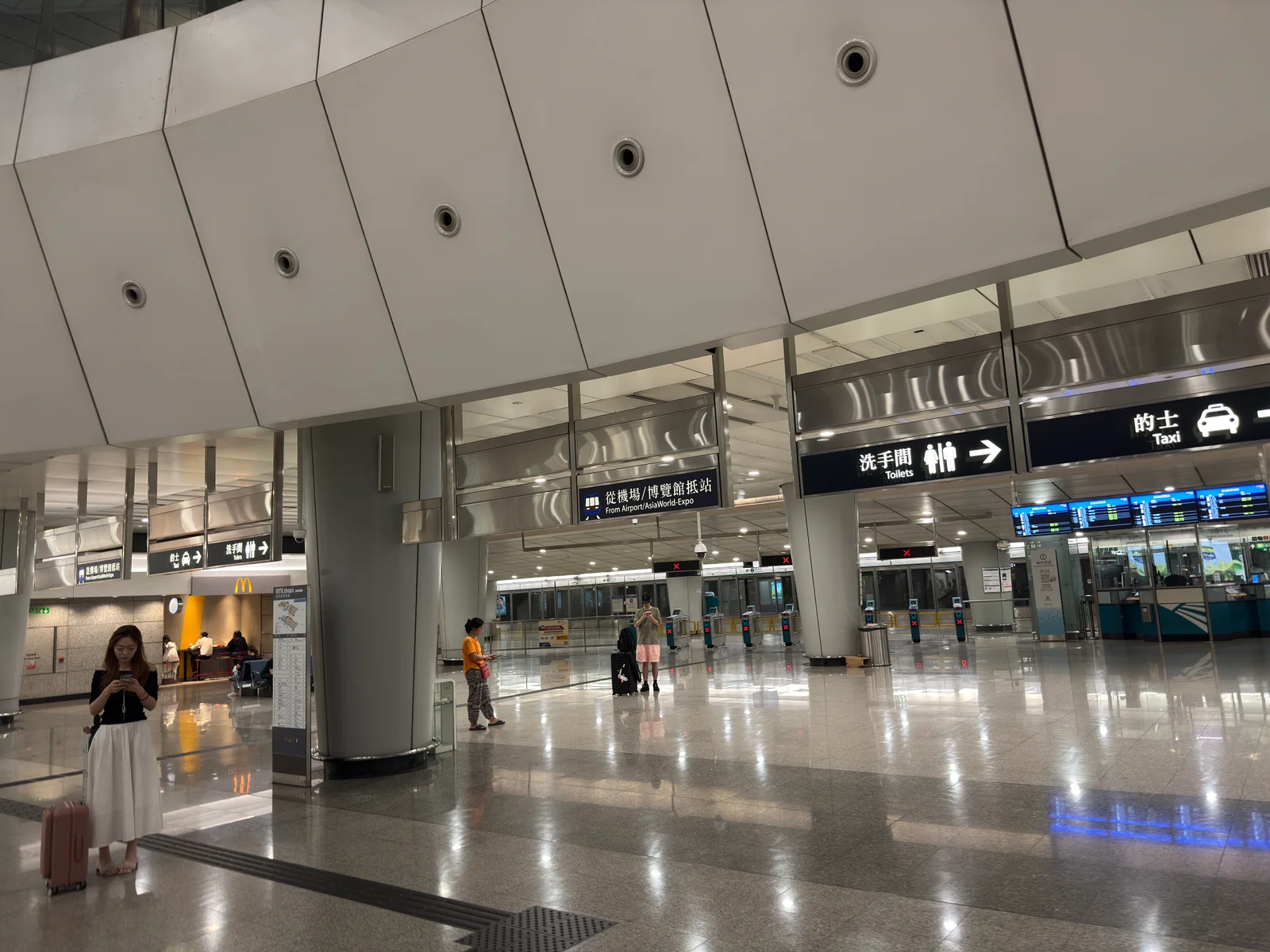 โถงผู้โดยสารขาเข้าที่สถานี Kowloon มีป้ายบอกทางไปแท็กซี่และห้องน้ำ