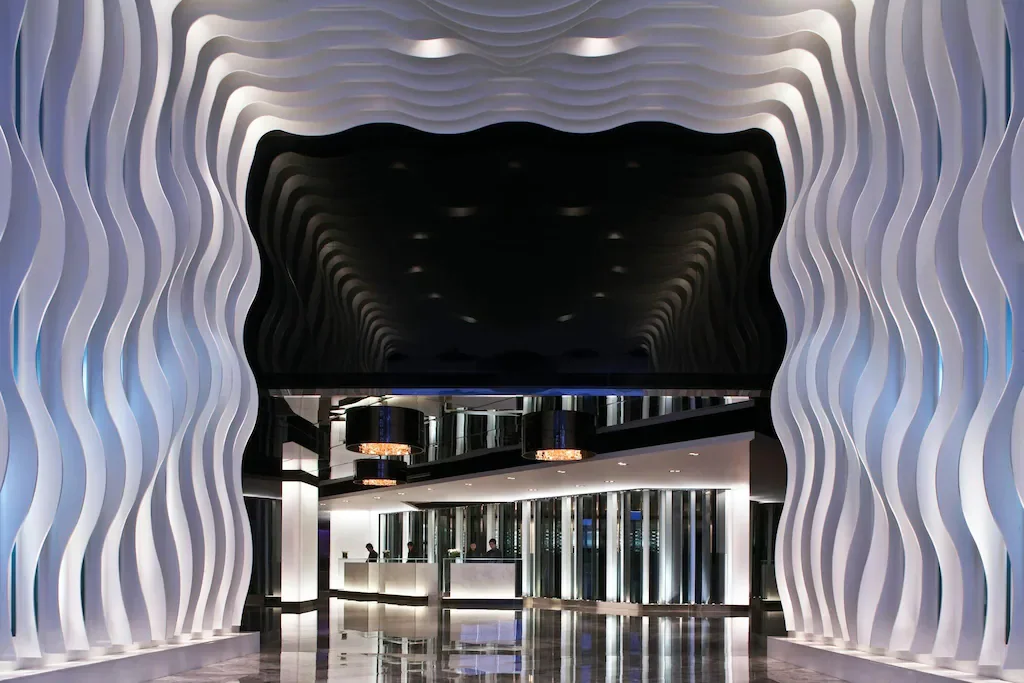 ทางเข้าล็อบบี้ของ The Mira Hong Kong ตกแต่งด้วยแผงสีขาวรูปคลื่น