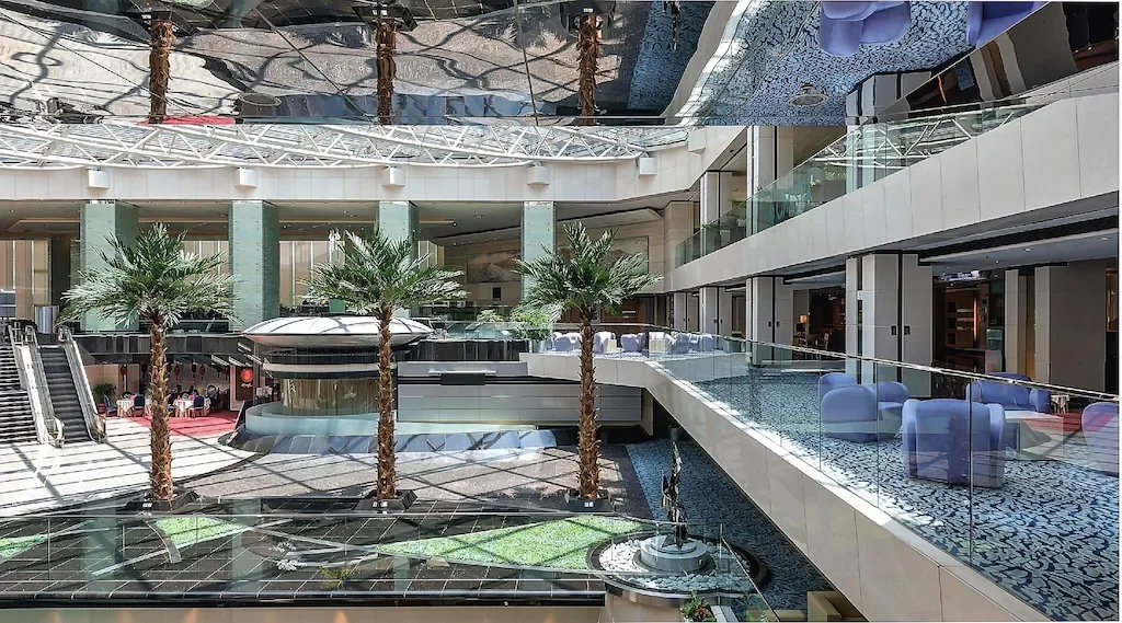 โถงล็อบบี้ของ Regal Airport Hotel มีบันไดเลื่อนและบริเวณที่นั่ง