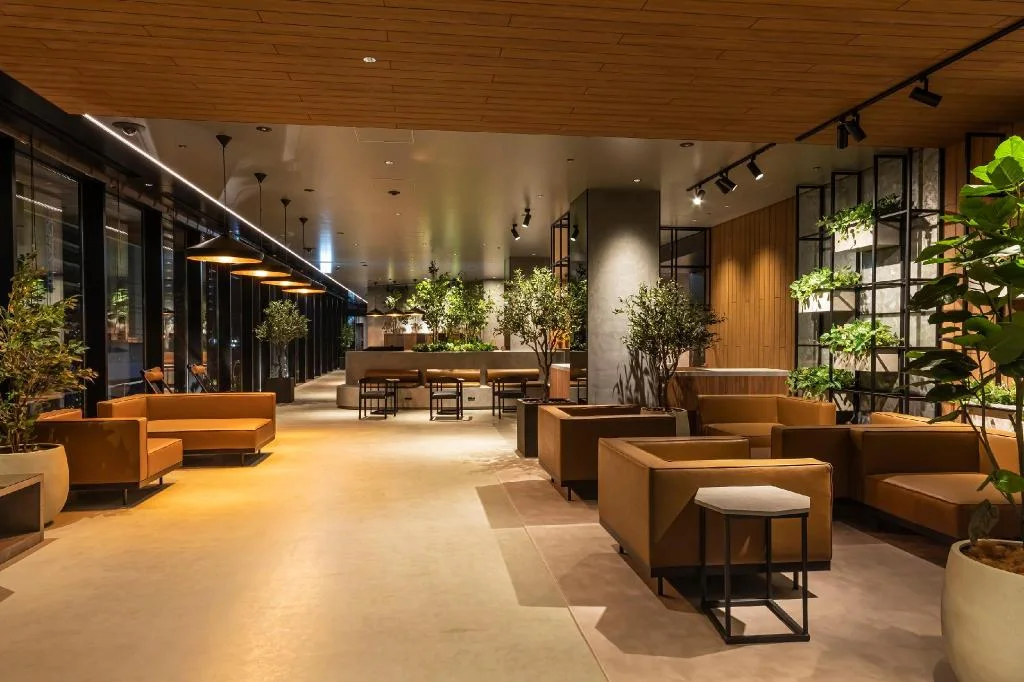 ที่นั่ง ต้นไม้ และโคมไฟแขวนในล็อบบี้ Hotel Keihan Namba Grande